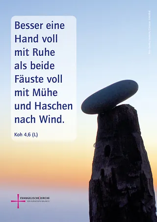Stein auf einem Holzpfahl vor Abendhimmel mit der Monatslosung September 2026: „Besser eine Hand voll mit Ruhe als beide Fäuste voll mit Mühe und Haschen nach Wind.“ (Kohelet 4,6).