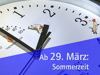 Auschnitt einer Uhr mit einer kleinen Figur die den kleinen Uhrzeiger verschiebt