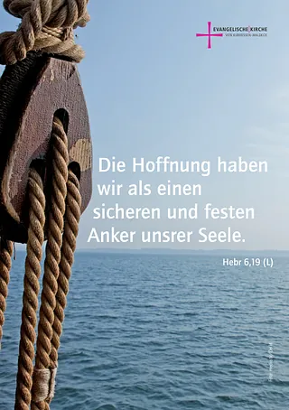Nahaufnahme einer Holz-Seilrolle, dahinter das Meer.